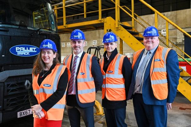 people in hard hats and high viz standing in front of truck