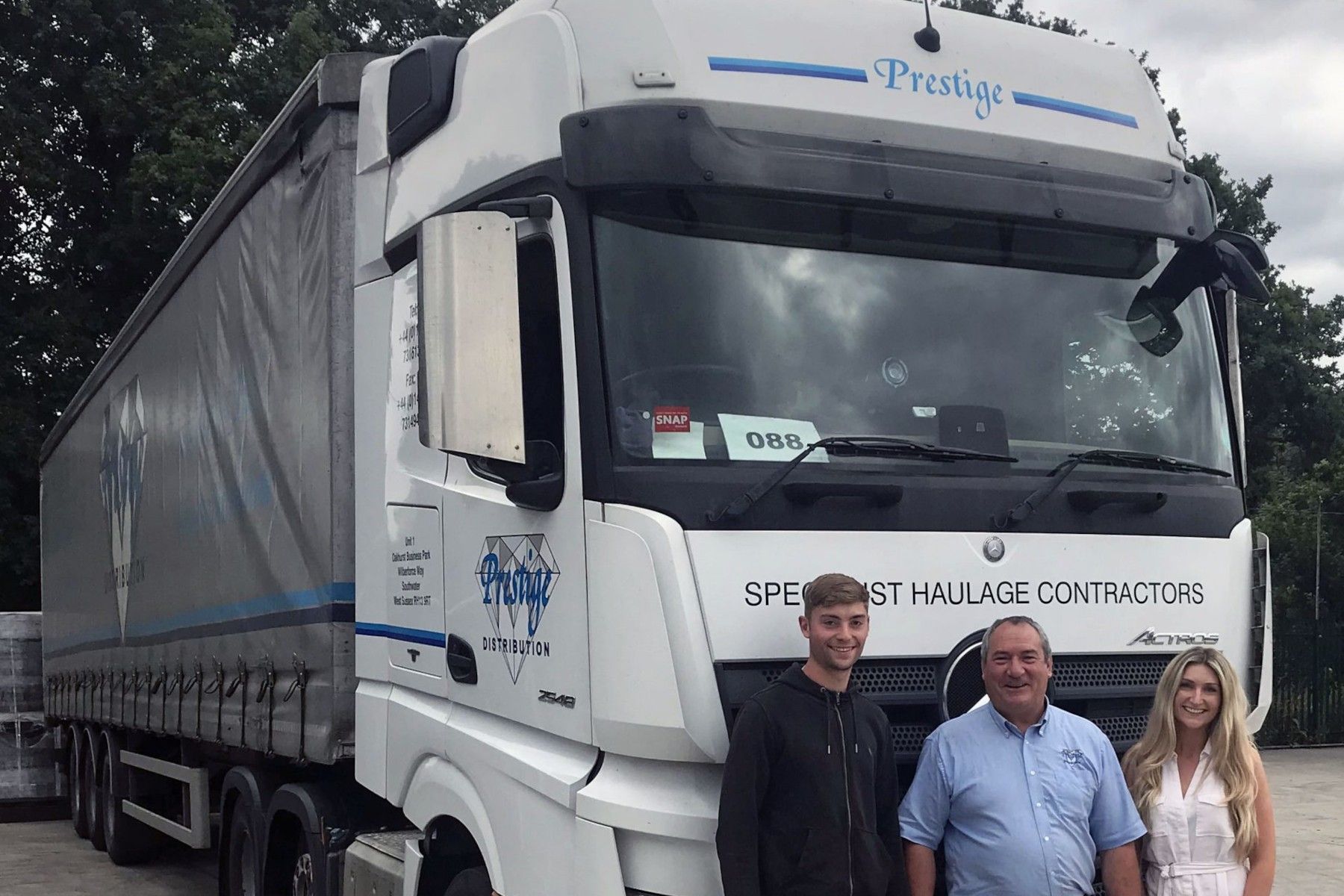 Prestige Lorry with three people in front of it